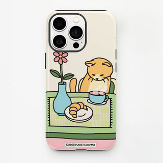 Phone case with a cartoon cat at a table, a flower, and a cup of coffee on a white background.